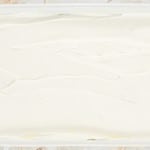 A white frosting in a white tray.