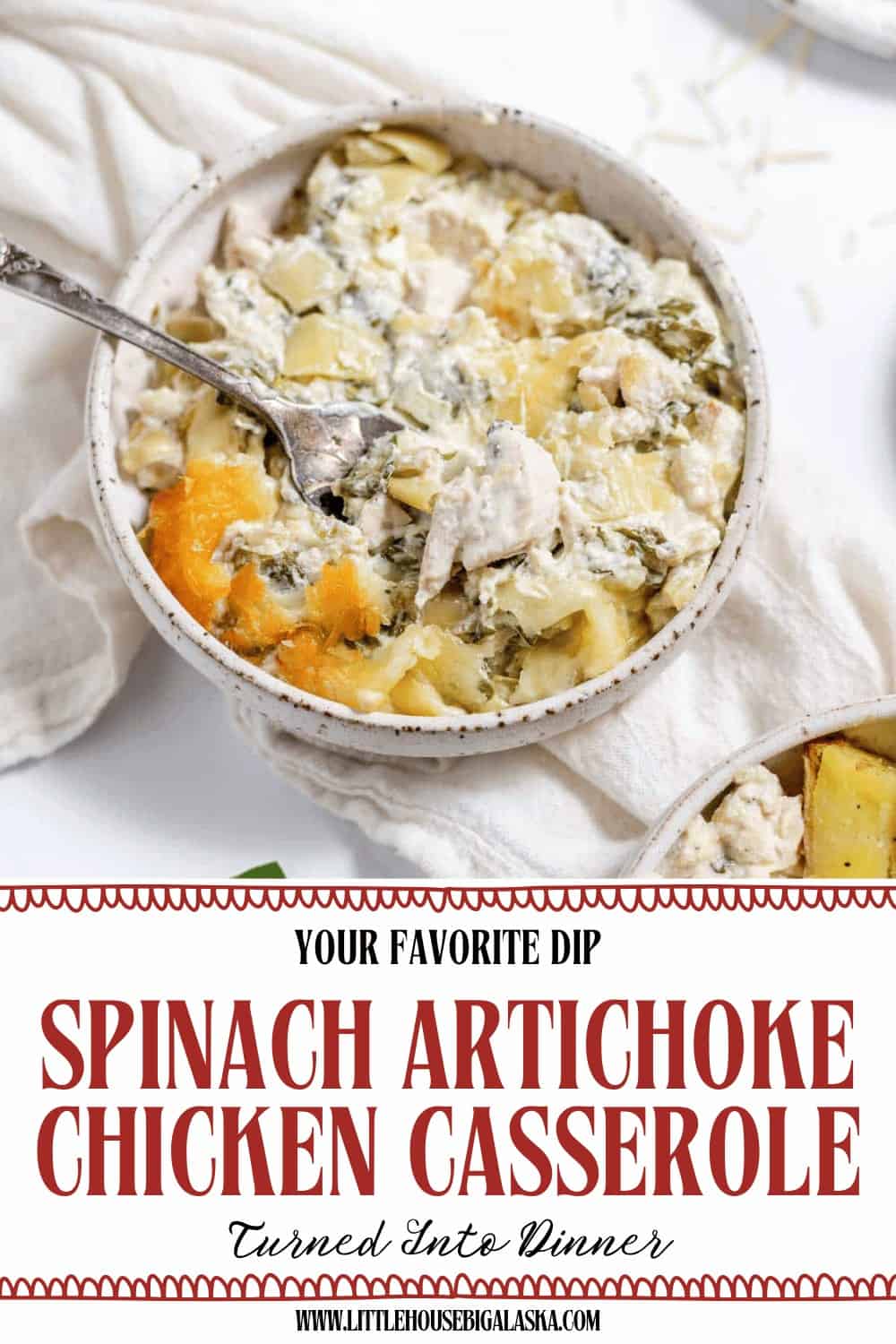 A bowl of creamy Spinach Artichoke Chicken Casserole with a spoon, served on a white surface, sits next to part of a baking dish filled with more casserole.
