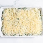 A casserole dish filled with spinach and cheese.