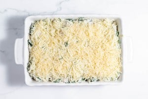 A casserole dish filled with spinach and cheese.