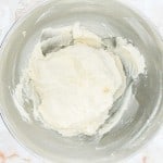 A bowl containing a mixture of ingredients, likely a batter or dough, on a marbled surface.
