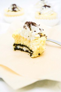A slice of mini cookies and cream cheesecakes on a paper napkin with a fork.