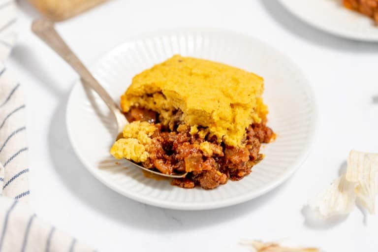 A serving of cornbread-topped casserole on a white plate.
