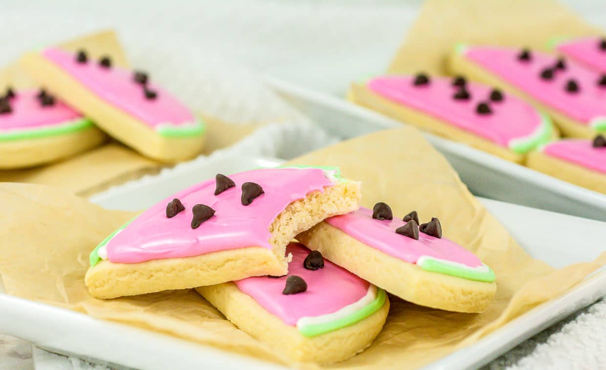 Sliced watermelon-shaped sugar cookies with pink icing and chocolate chip