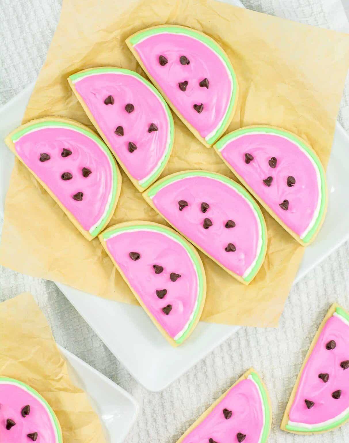 Sliced watermelon-shaped sugar cookies with pink icing and chocolate chip