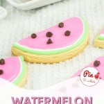 Colorful watermelon-themed cookies decorated with pink and green icing and chocolate chips.