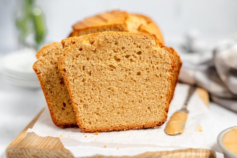 Sliced peanut butter bread on a wooden board with a knife.