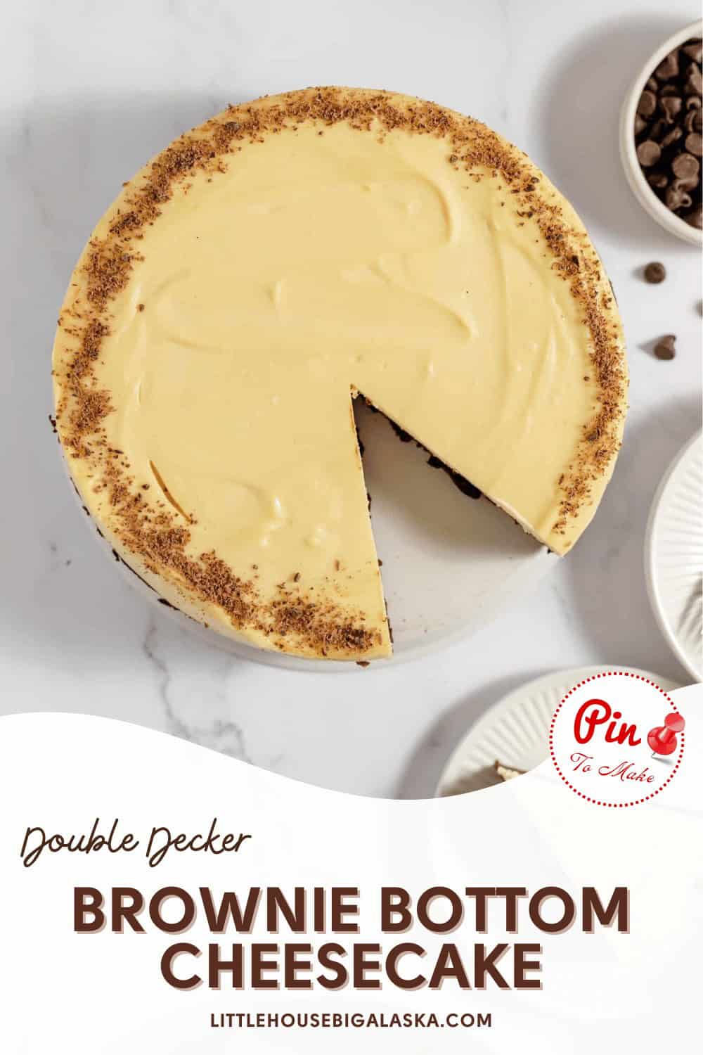 A double decker brownie bottom cheesecake with one slice partially removed, displayed on a white surface, with chocolate chips and a Pinterest pin icon visible.