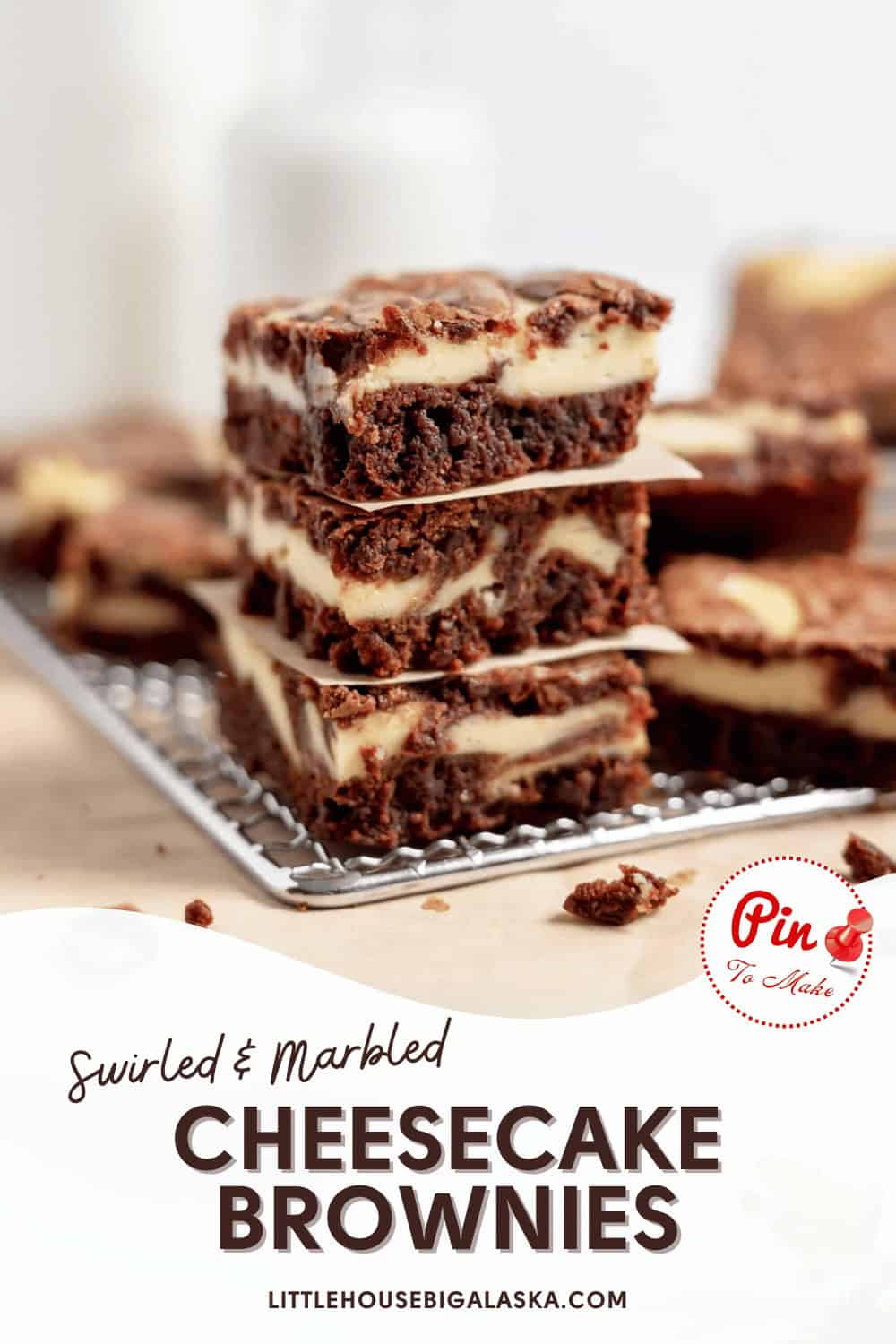 A stack of swirled and marbled cheesecake brownies on a cooling rack. The text at the bottom reads, "Swirled & Marbled Cheesecake Brownies - littlehousebigalaska.com.