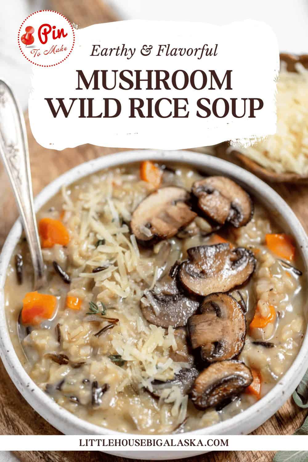 A bowl of mushroom wild rice soup with sliced mushrooms and carrots on top, accompanied by a spoon. The image includes text: "Earthy & Flavorful Mushroom Wild Rice Soup" and a website URL "littlehousebigalaska.com".