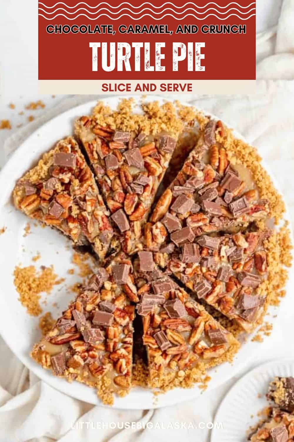 A delicious turtle pie topped with chopped pecans and chocolate pieces is sliced and displayed on a white plate, with crumbs scattered around.
