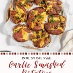 Baked smashed potatoes with garlic, arranged on parchment atop a wooden tray and garnished with herbs. Text overlay reads: "Boil, Smash, Bake Smashed Potatoes That's It.