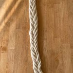 A braided dough strand rests on a wooden surface.