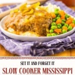 A plate of Slow Cooker Mississippi Salisbury Steaks with brown gravy, mashed potatoes, peas, and carrots, garnished with sliced peppers, sits on a purple patterned cloth.