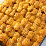 A baking dish filled with a baked casserole topped with golden-brown tater tots and melted cheese.