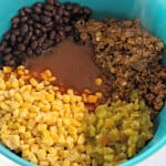 A bowl with black beans, ground beef, corn, and chopped green peppers.