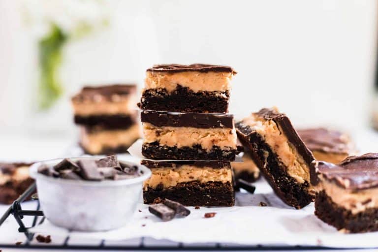 A delectable stack of chocolate peanut butter bars graces the cooling rack, their rich aroma a testament to the perfect peanut butter dessert. Nearby, a small container spills over with chocolate chunks, tempting even the strongest willpower.