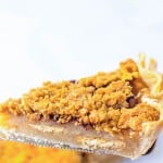 A slice of pie, one of the iconic pie favorites, with a crumbly topping rests invitingly on a fork against a delicately blurred background.