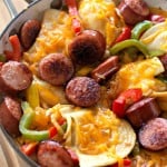 Kielbasa skillet featuring sliced sausage, bell peppers, onions, potatoes, and melted cheese.