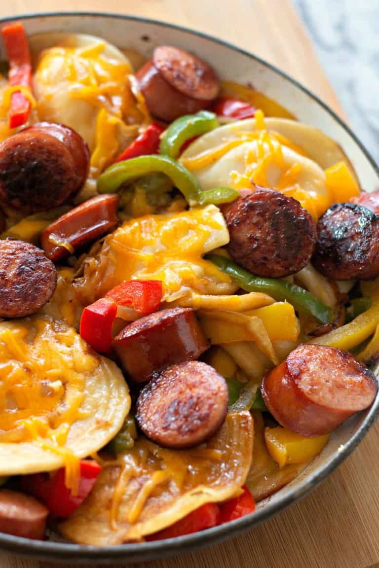 A savory Pierogi and Kielbasa Skillet features sliced kielbasa sausage, vibrant bell peppers, and tender pierogies all topped with a layer of melted cheese, sizzling together perfectly in a single skillet.