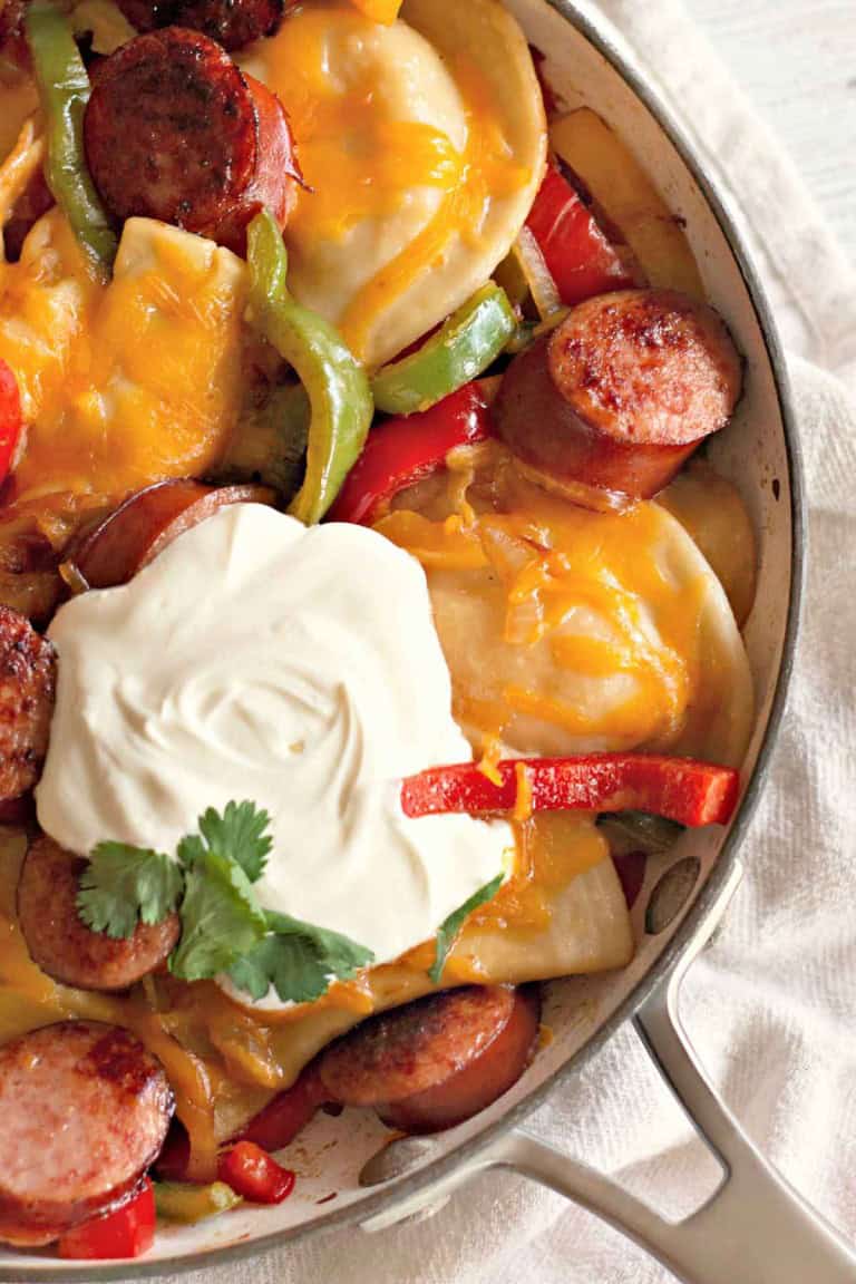 Enjoy a warm Pierogi and Kielbasa Skillet featuring pierogies, sliced sausage, vibrant bell peppers, and bubbling melted cheese. Finish it with a dollop of sour cream and sprinkle of fresh cilantro for a delightful culinary experience.