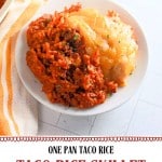 A serving of cheesy taco rice skillet is on a white plate next to an orange-striped towel. Text at the bottom promotes this taco rice skillet recipe as a family favorite dinner.