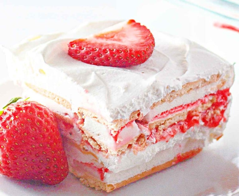 A slice of strawberry icebox cake with layers of whipped cream and cookies, reminiscent of a delightful strawberry ice cream cake, topped with sliced strawberries.