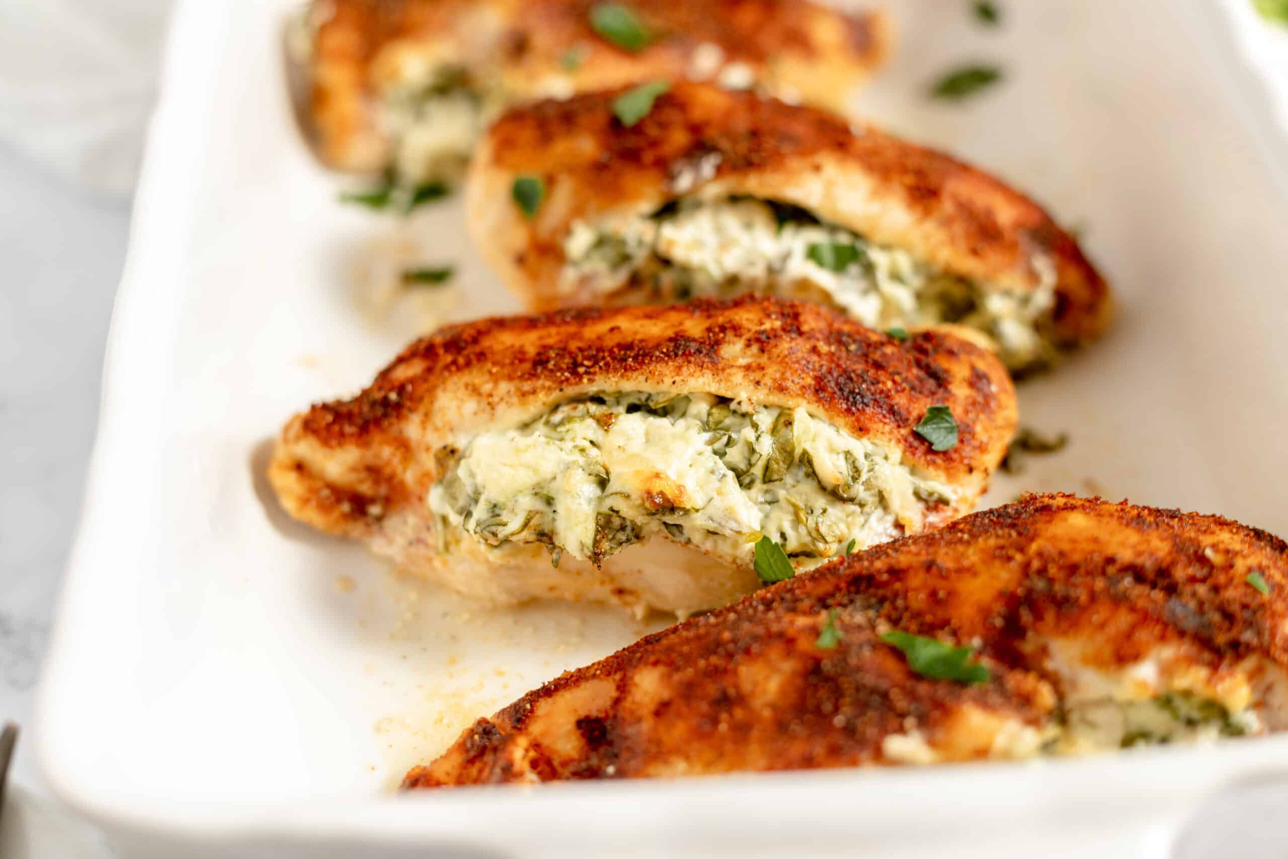 A baking dish full of stuffed chicken breasts.