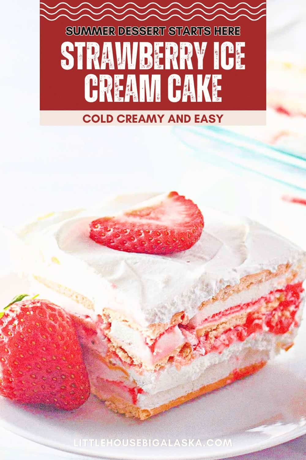 A slice of Strawberry Ice Cream Cake topped with a fresh strawberry, served alongside another whole strawberry—this cold, creamy treat is the perfect easy summer dessert.