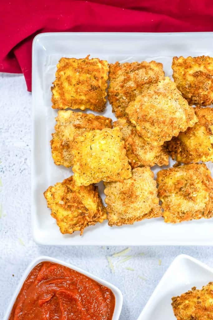 A crispy ravioli about to be dipped.