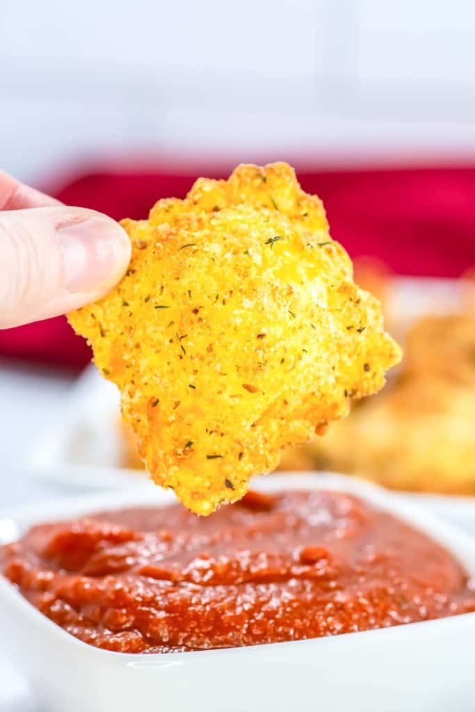 A crispy ravioli about to be dipped.