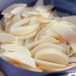 Thinly sliced apples in a non-stick pan, perfect for creating an apple crumb Danish or other delicious baked treats.