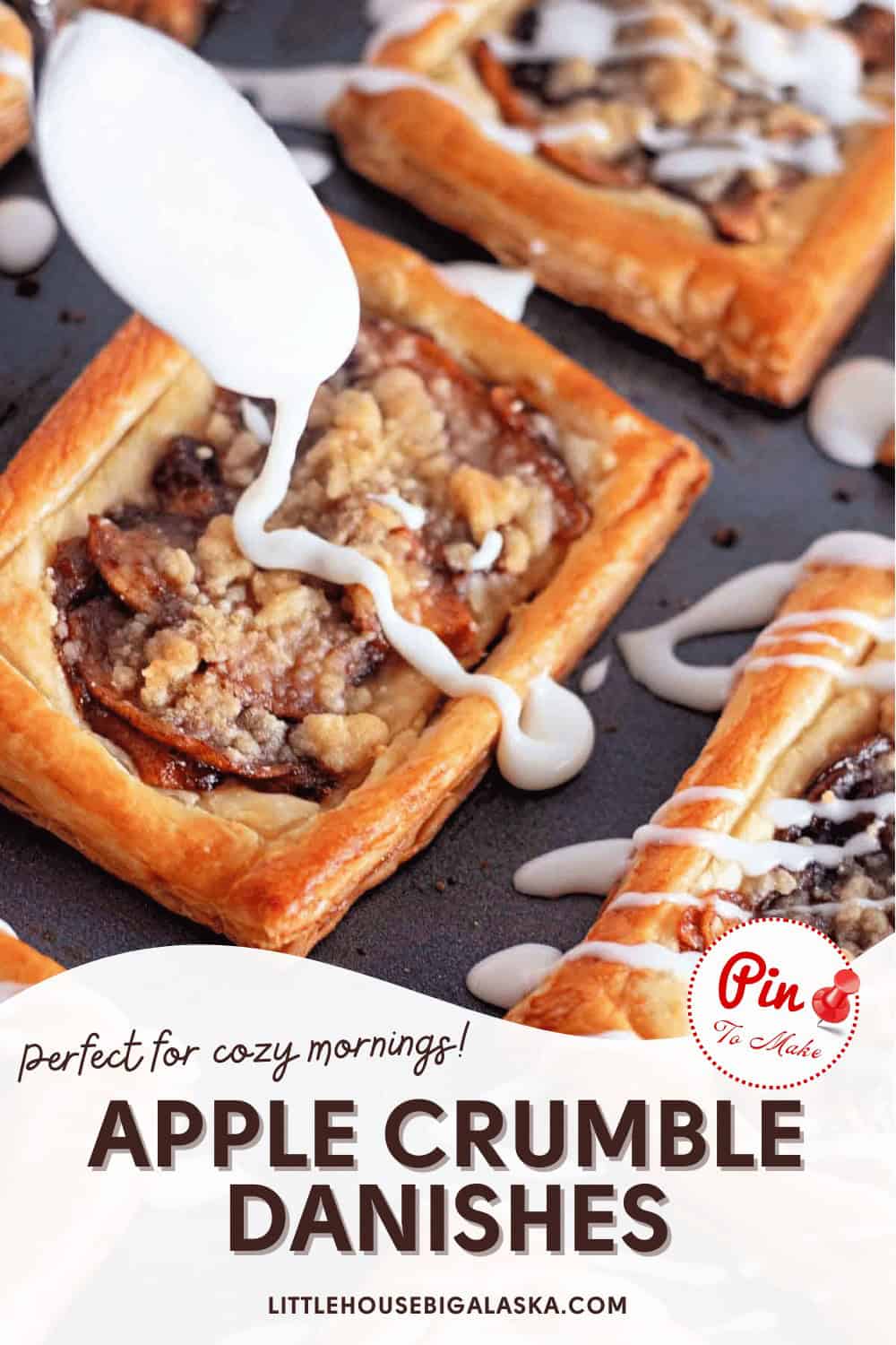 Close-up of apple crumble danishes on a baking tray, drizzled with white icing. Text reads: "Perfect for cozy mornings! Apple Crumble Danishes" with "LittleHouseBigAlaska.com" at the bottom.