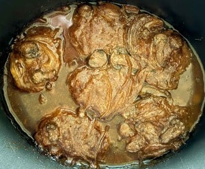A hearty slow cooker Salisbury steak, bathed in a rich dark sauce, elegantly displayed in a pot.