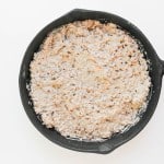 A black skillet filled with a creamy, mixed ground meat and sauce mixture on a white background.