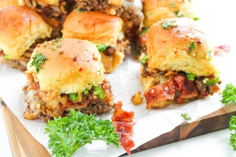 Cowboy sliders on a wooden board, garnished with fresh parsley.