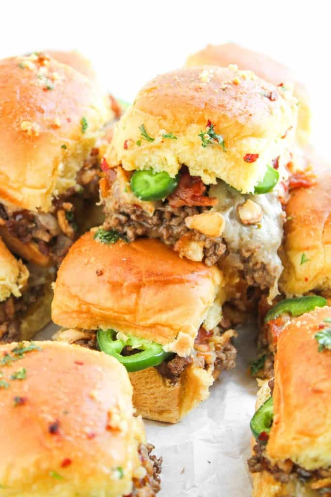 Cowboy sliders on a wooden board, garnished with fresh parsley.