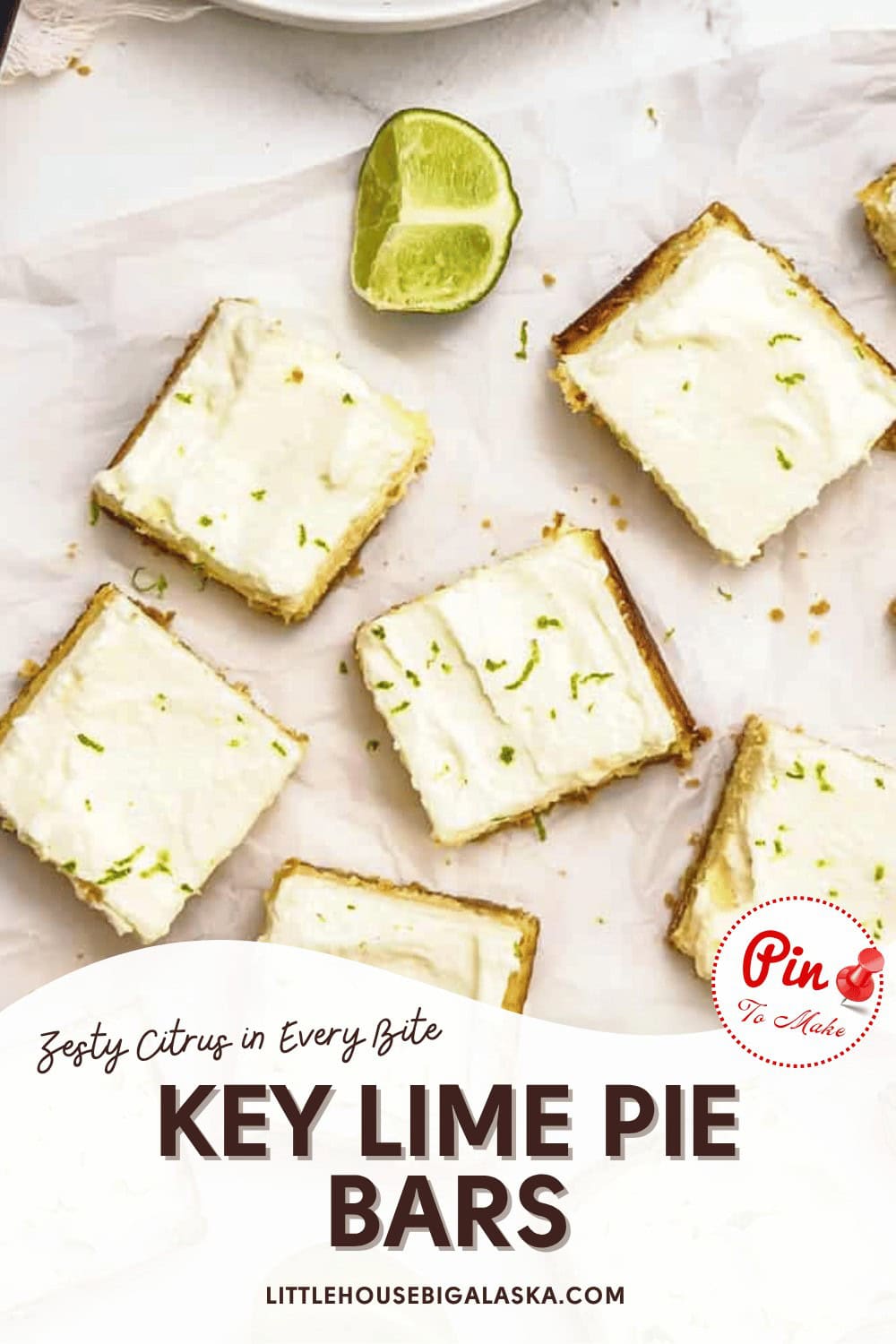 Overhead view of key lime pie bars topped with white frosting and lime zest, arranged on parchment paper with a halved lime nearby.