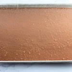 A baking sheet filled with raw chocolate cake batter, ready to be baked.