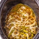 Ground meat, sliced onions, and green bell peppers cooked together in a slow cooker with broth or sauce.