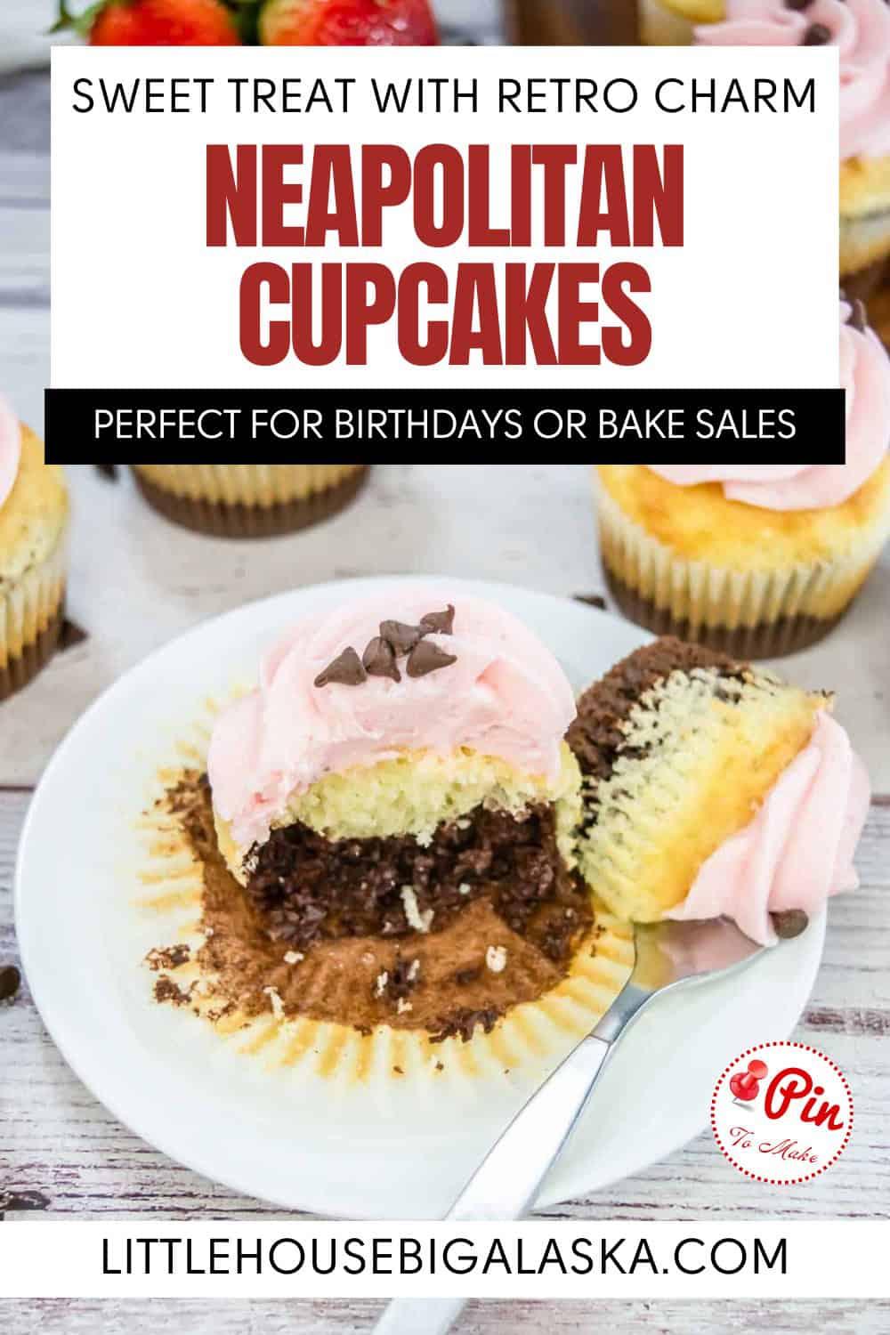 A plate with a Neapolitan cupcake, cut open to show chocolate, vanilla, and strawberry layers, sits on a table with more decorated cupcakes in the background.