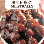 A white bowl filled with Slow Cooker Hot Honey Meatballs, glazed in a rich, dark sauce for the perfect sweet and spicy appetizer.