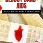 Rectangular wafer cookies with a white icing strip and a red gel center resemble Bloody Band-Aids, arranged neatly on a white surface.