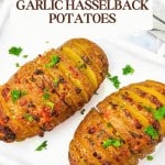 Two Garlic Hasselback Potatoes, sliced and baked with herbs, are served on a white plate and garnished with parsley. The recipe text and website info highlight these flavorful Garlic Hasselback Potatoes.