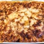 Golden-brown cobbler topped with melted cinnamon sugar crust, baked in a rectangular dish.