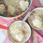 A group of bowls of soup with spoons.