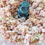 Minced ham, pickles, and other ingredients mixed in a food processor.