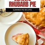 A slice of classic rhubarb pie on a plate next to a pie server, with the rest of the pie in the background on a red and white cloth.
