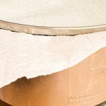 A slow cooker with a paper towel placed under its glass lid to catch condensation.