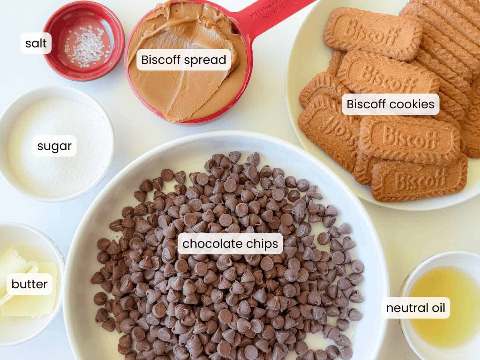 Ingredients for Biscoff Cups are arranged on a table: Biscoff cookies, Biscoff spread, chocolate chips, sugar, butter, salt, and neutral oil, each labeled.